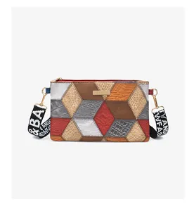 Close-up of color-block geometric pattern and gold hardware on crossbody bag
