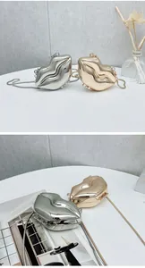 Detail of creative lip-shaped evening bag with high-shine metallic finish and snake chain