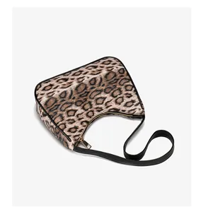 Détail du sac croissant à imprimé léopard avec bordure en cuir noir et zip doré