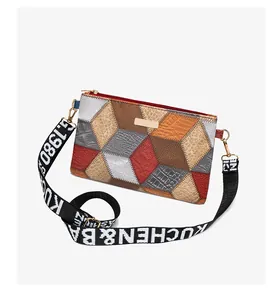 Detailed view of cubic patchwork crossbody bag with textured leather and wide strap