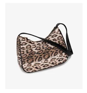 Détail de sac à bandoulière léopard avec sangle noire et fermeture éclair dorée