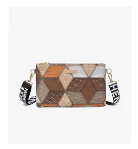 Detail of color-block cube crossbody bag with textured faux leather and metal nameplate