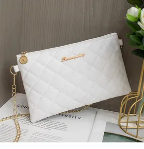 Détail du sac matelassé blanc en similicuir avec logo doré et bandoulière chaîne