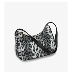 Détail du sac lune à motif léopard avec bordure en cuir noir et fermeture éclair dorée