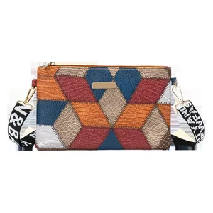 Color-block cube crossbody bag with geometric patterns and a wide woven strap