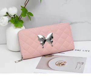 Detailed view of pink quilted long wallet with a silver butterfly metal ornament