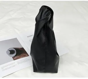 Detail of black cloud bag featuring a knotted handle and premium lychee texture leather