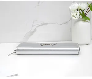 Macro detail of silver long wallet with sleek metal finish and butterfly zipper pull