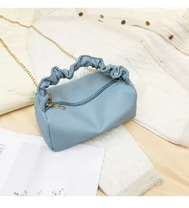 Detailed macro view of light blue lychee pattern leather bag with gold chain strap