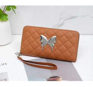 Macro shot of brown quilted leather long wallet with silver butterfly ornament and hand strap