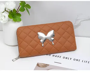 Detail of caramel quilted wallet with metallic silver butterfly and secure zipper