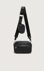 Detail of black quilted crossbody bag with adjustable wide strap and mini coin purse