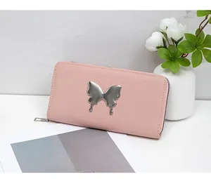 Detailed view of pink leather long wallet featuring a large silver metal butterfly clasp