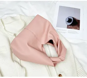 Detail of light pink cloud bag showing premium pebble grain texture and knot handle