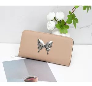 Macro detail of almond long wallet featuring a liquid metal butterfly buckle on faux leather