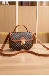 Close-up of geometric pattern, caramel leather trim, and gold clasp on the bag