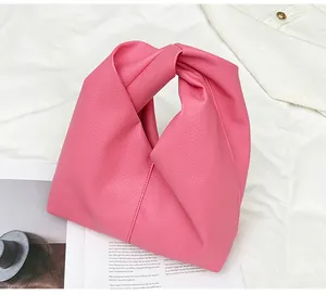Detail of rose pink lychee texture PU leather dumpling bag with twisted handle design