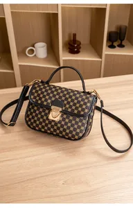 Detail of vintage brown leather handbag featuring golden circular patterns and metal lock