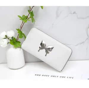 Detail of white leather long wallet with silver butterfly ornament and zipper closure
