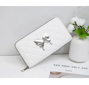 Detailed view of white quilted long leather wallet with silver butterfly metal ornament