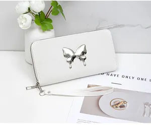 Close-up of white leather long wallet with silver butterfly ornament and wrist strap