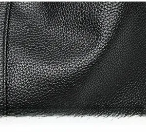 Close-up of premium black lychee texture leather with delicate grain and soft glossy finish