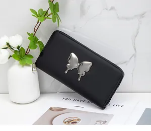 Close-up of black leather zip-around wallet with silver liquid metal butterfly decoration