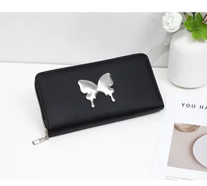 Close-up of a black matte leather long wallet with a silver fluid butterfly metal emblem