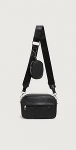 Detail of quilted crossbody bag featuring adjustable wide strap and detachable coin purse
