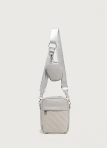 Dettaglio borsa a tracolla trapuntata beige con ampia tracolla in tessuto e mini tasca