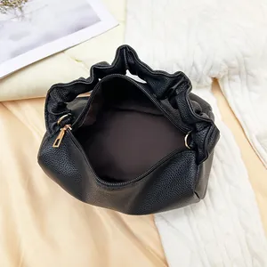 Litchi pattern crossbody bag with pleated handle and brown fabric lining