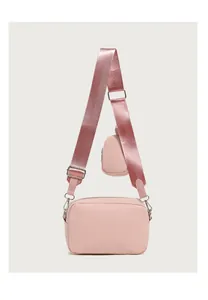 Detail of pink quilted crossbody bag with matching round mini coin purse and wide strap