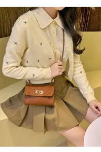Macro view of brown quilted crossbody bag with a golden turn-lock clasp on a model