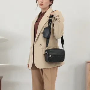 Quilted crossbody bag with a wide shoulder strap and a detachable round coin purse on a model