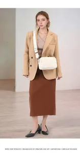 White litchi pattern crossbody bag with wide jacquard strap shown on camel blazer outfit