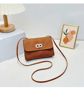 Macro view of brown quilted crossbody bag with golden twist lock and rivet details