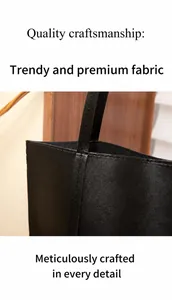 Detail shot of black faux leather tote bag showing refined texture and reinforced stitching