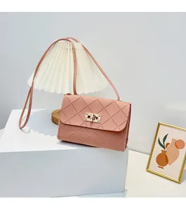 Pink quilted crossbody bag with gold twist lock on a minimalist white platform