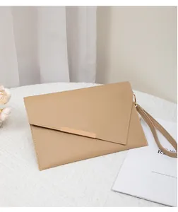 Detail der khakifarbenen Umschlag-Clutch mit asymmetrischer Klappe und Gold-Zierleiste