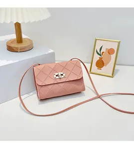 Close-up of pink quilted crossbody bag featuring a golden twist lock and rhombus pattern