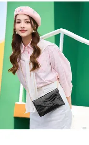 Close-up of black crocodile pattern leather texture on a woman's crossbody chain bag