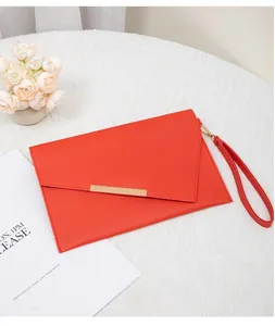 Detailansicht der roten Umschlag-Clutch mit goldener Metallschiene und Handschlaufe