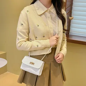 Chic white quilted crossbody bag with gold twist lock shown on model with casual outfit
