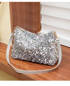 Detailed macro view of silver sequins texture and golden metal buckle on the shoulder bag