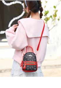 Vue de dos d'un mini sac à dos floral noir et rouge sur un sweat-shirt rose à capuche