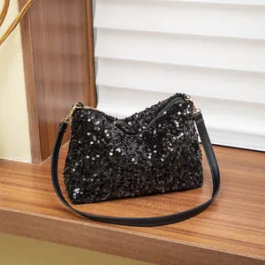 Fashion black sequin shoulder bag with gold hardware on a wooden display stand