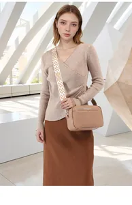 Close-up of beige litchi pattern crossbody bag with a wide geometric woven shoulder strap