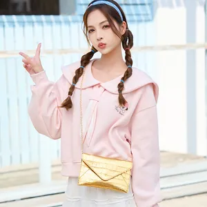 Fashionable gold crocodile pattern envelope chain bag worn by a model on the shoulder