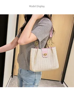 Model wearing woven straw tote with pink leather flap and gold clasp detail
