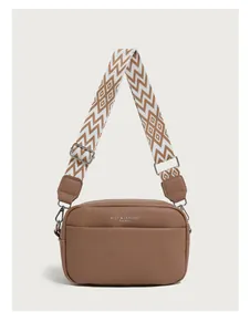 Detailed view of brown litchi pattern leather bag with wide geometric woven strap